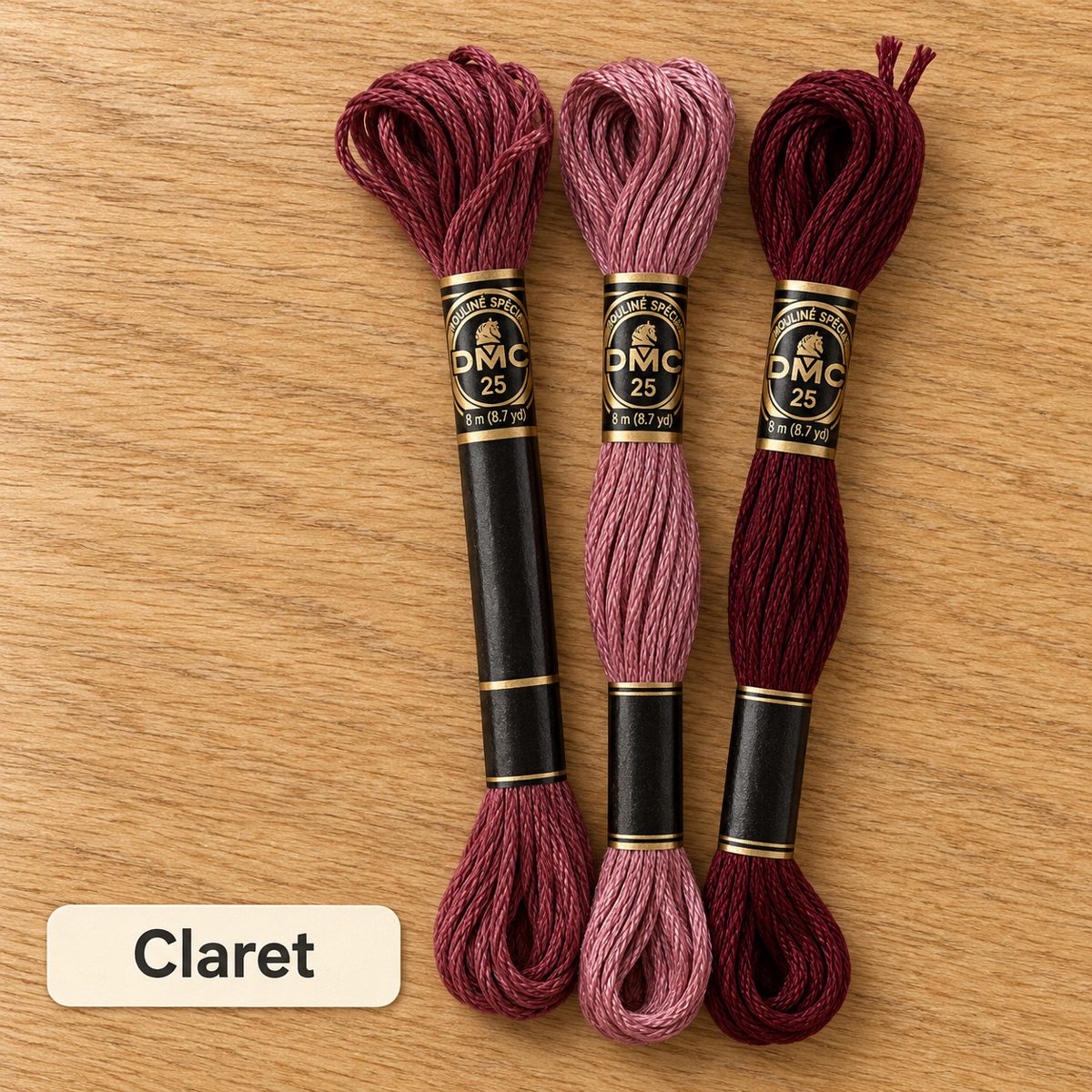 Claret palette: three DMC six-strand embroidery floss skeins